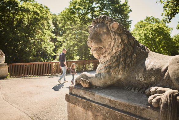 Menschen gehen über die Löwenbrücke im Schlosspark Laxenburg.
